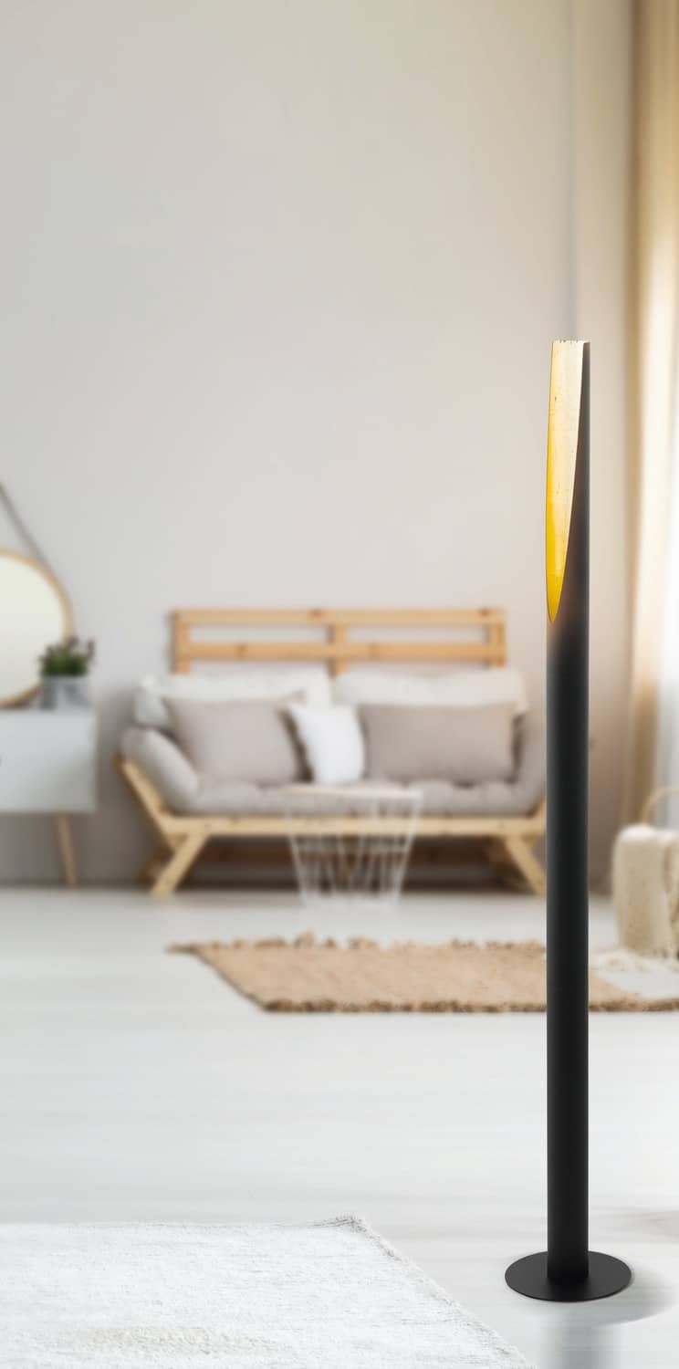 Ambiance de chambre claire avec le lampadaire doré près d'un canapé en bois