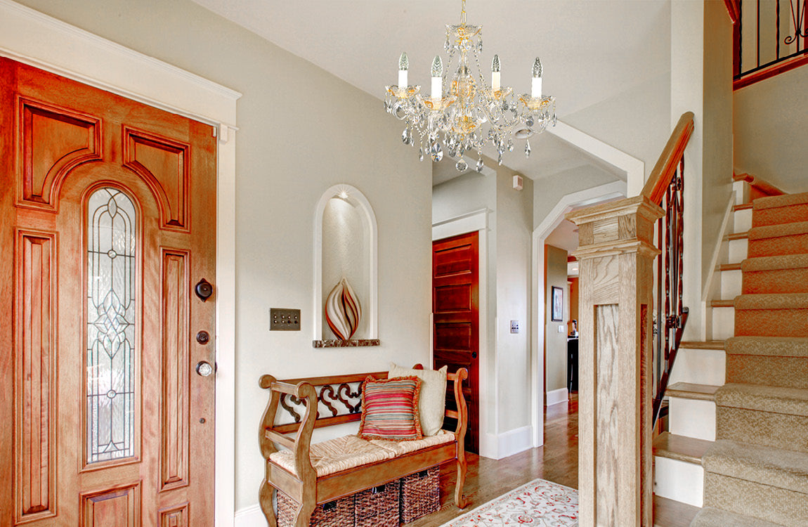 Mise en ambiance du lustre suspendu dans un hall d'entrée avec porte en bois et escalier