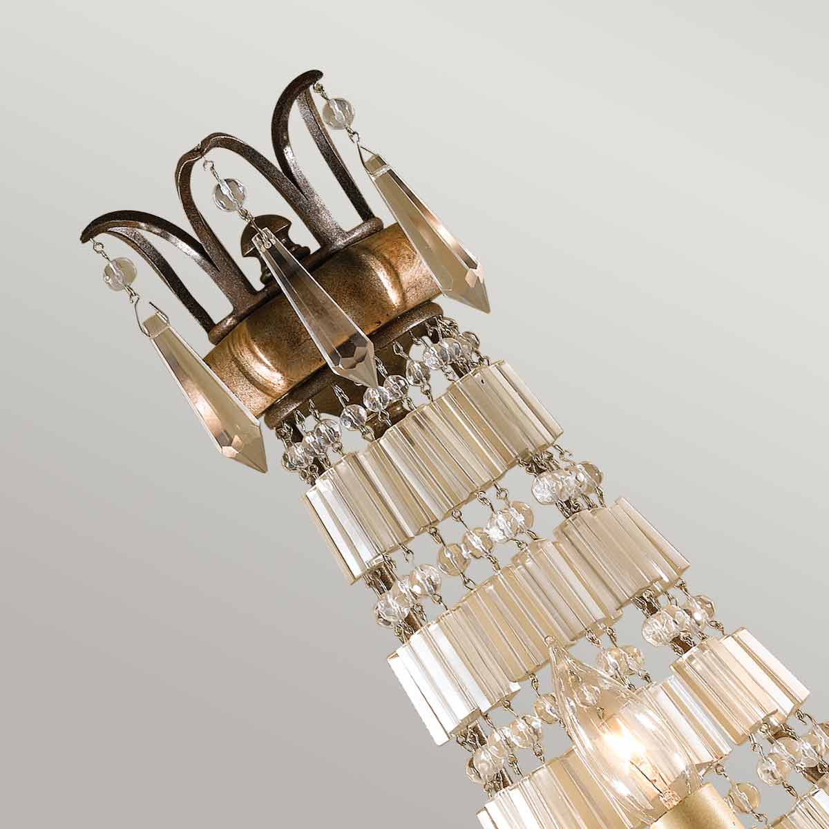 Gros plan sur la couronne supérieure en métal bronze et les chaînes de cristal.