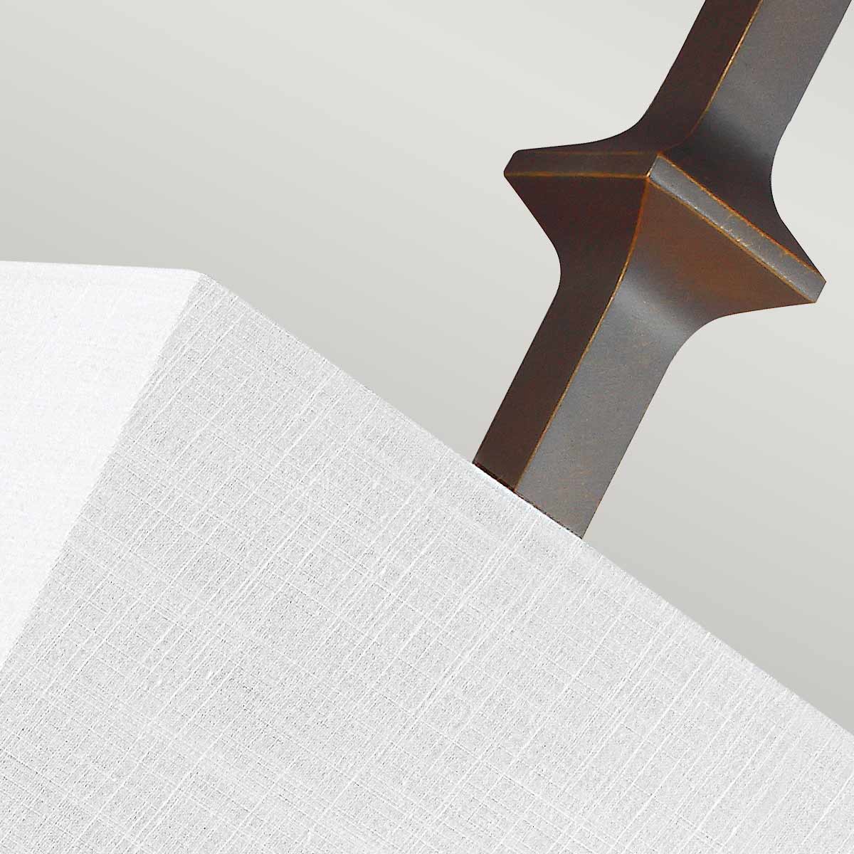 Détail du fût bronze brossé traversant l'abat-jour en tissu texturé clair