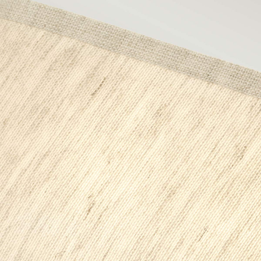 Zoom sur la texture tissée de l'abat-jour beige et sa finition ourlée