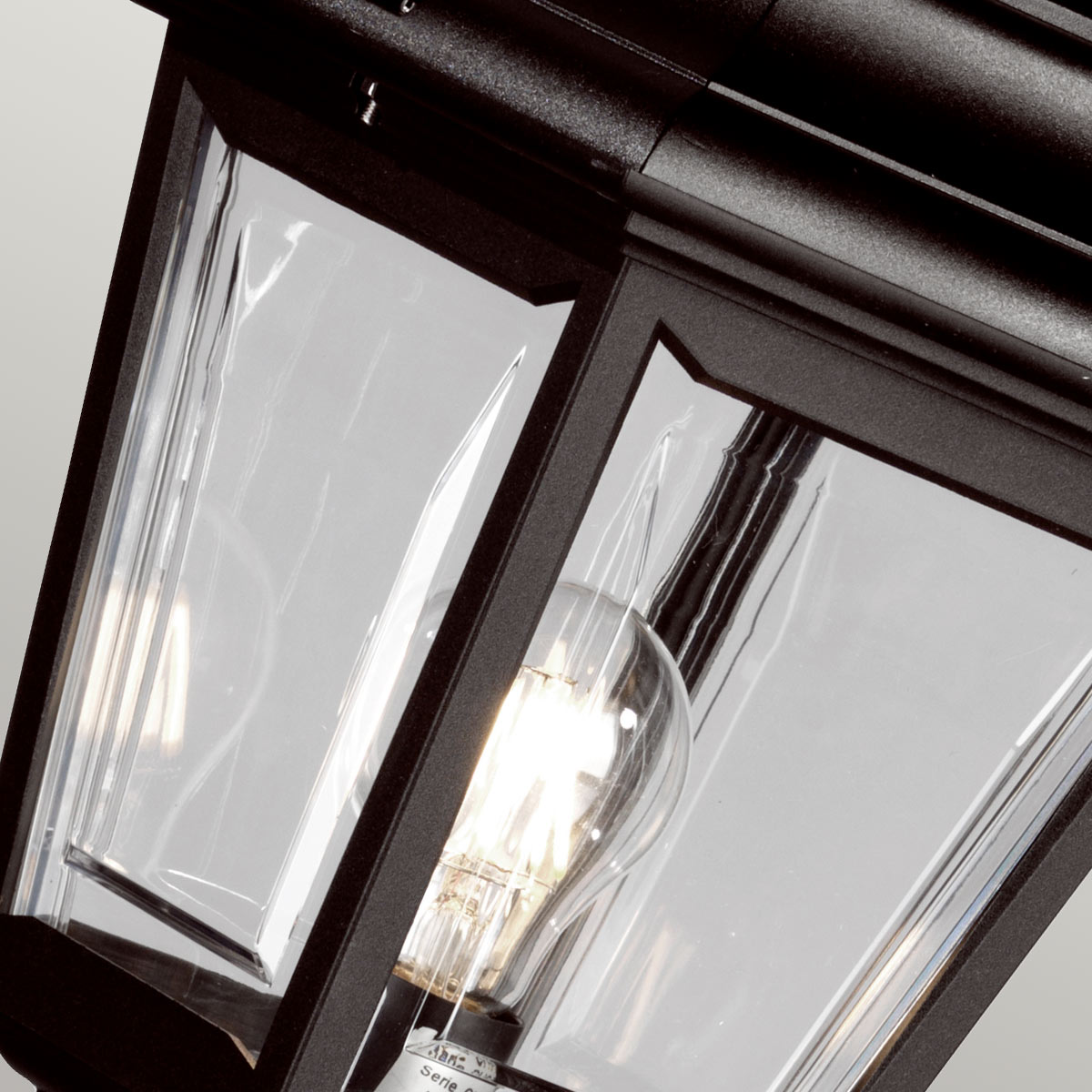 Détail des panneaux de verre transparent et de l'ampoule allumée dans la lanterne
