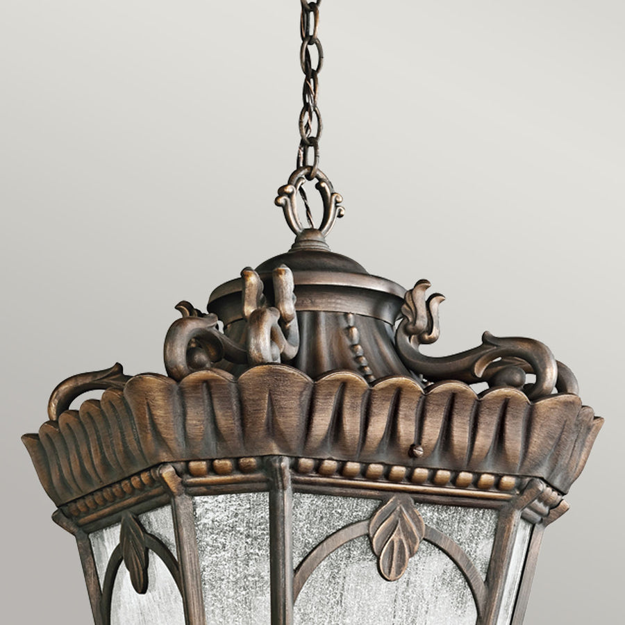 Détail du sommet : volutes, godrons et feuilles d'acanthe en métal bronze patiné.