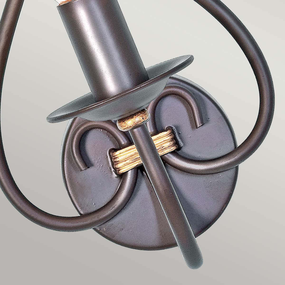 Détail de la platine ronde murale avec attaches et bagues dorées torsadées