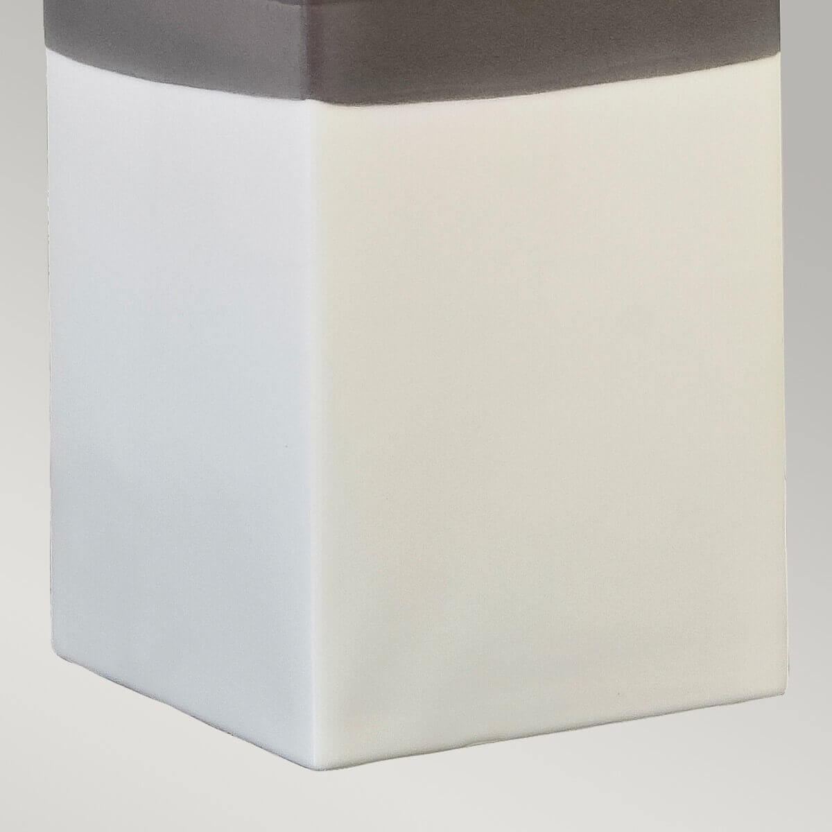 Gros plan sur le bas du socle céramique et la démarcation entre gris et crème.