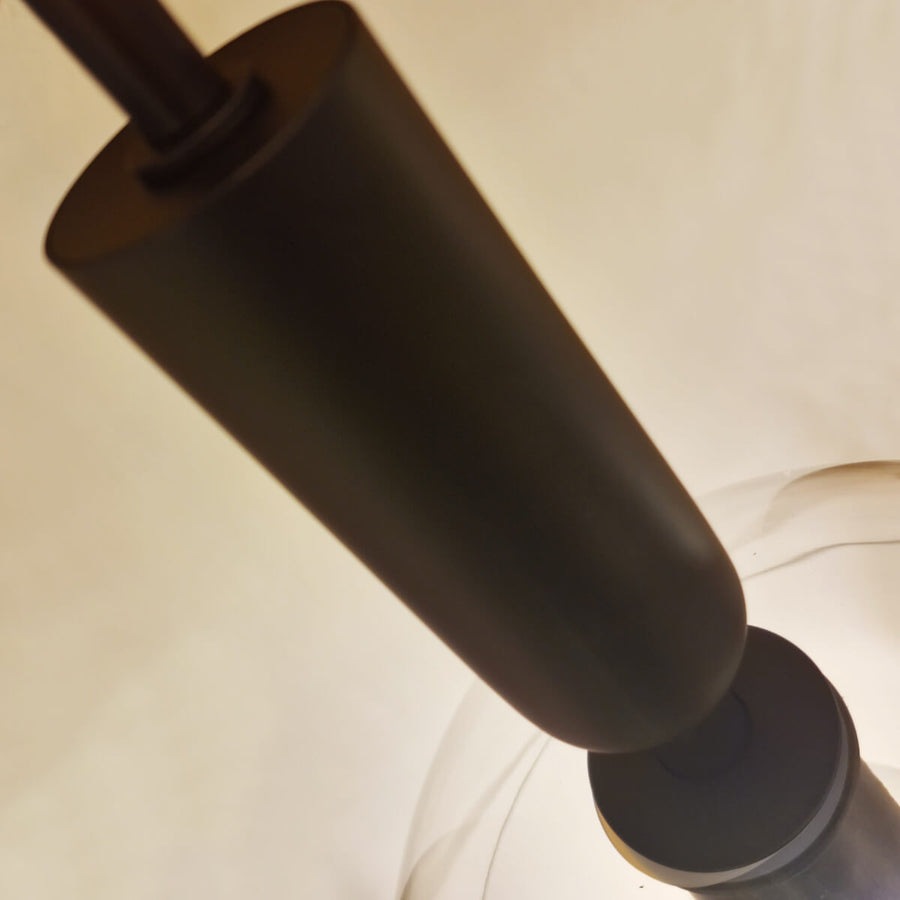 Plan serré sur le cylindre noir et la bague qui maintient le verre.