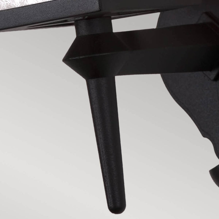 Détail du bras de fixation noir et de la tige verticale sous le boîtier