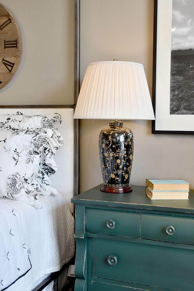 Vue de la lampe depuis le lit, avec horloge murale et cadre photo