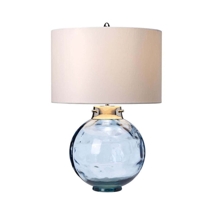 Même lampe allumée, abat-jour diffusant une lumière chaude sur fond neutre