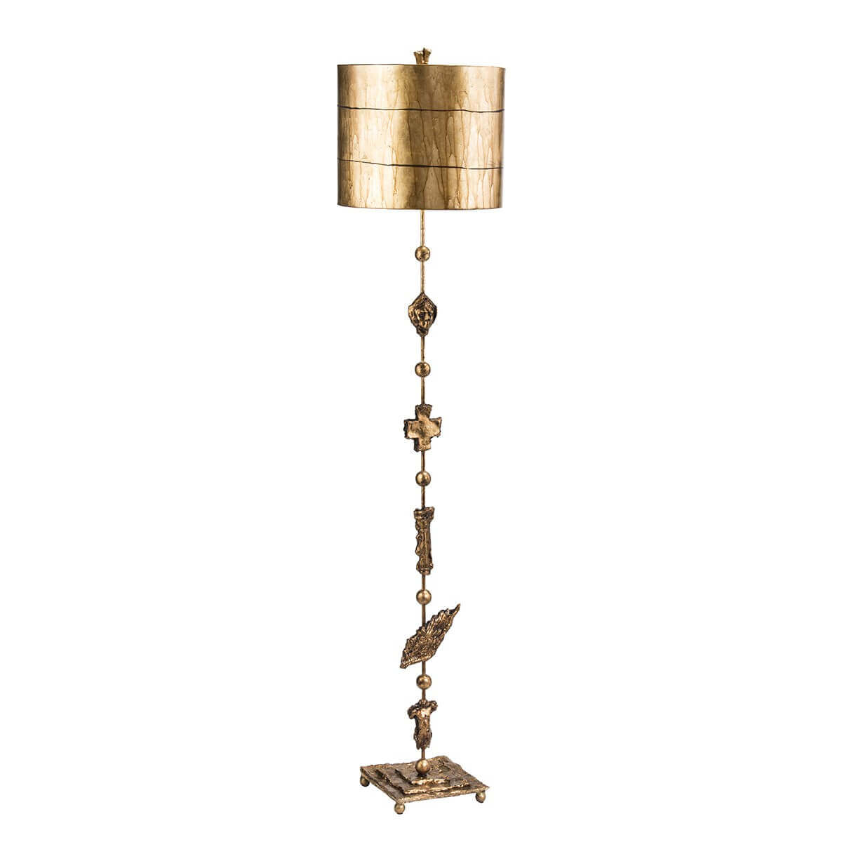 Lampadaire doré entier vu de face, abat-jour cylindrique et fût sculpté sur fond blanc.