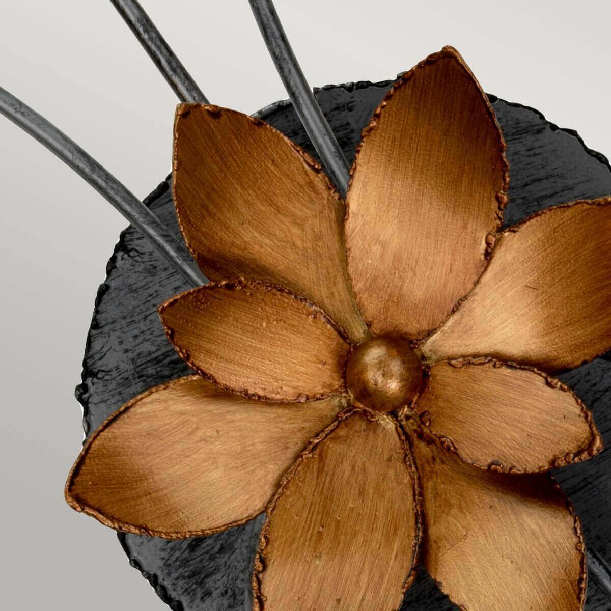 Gros plan sur la fleur dorée centrale fixée sur une rosace noire martelée