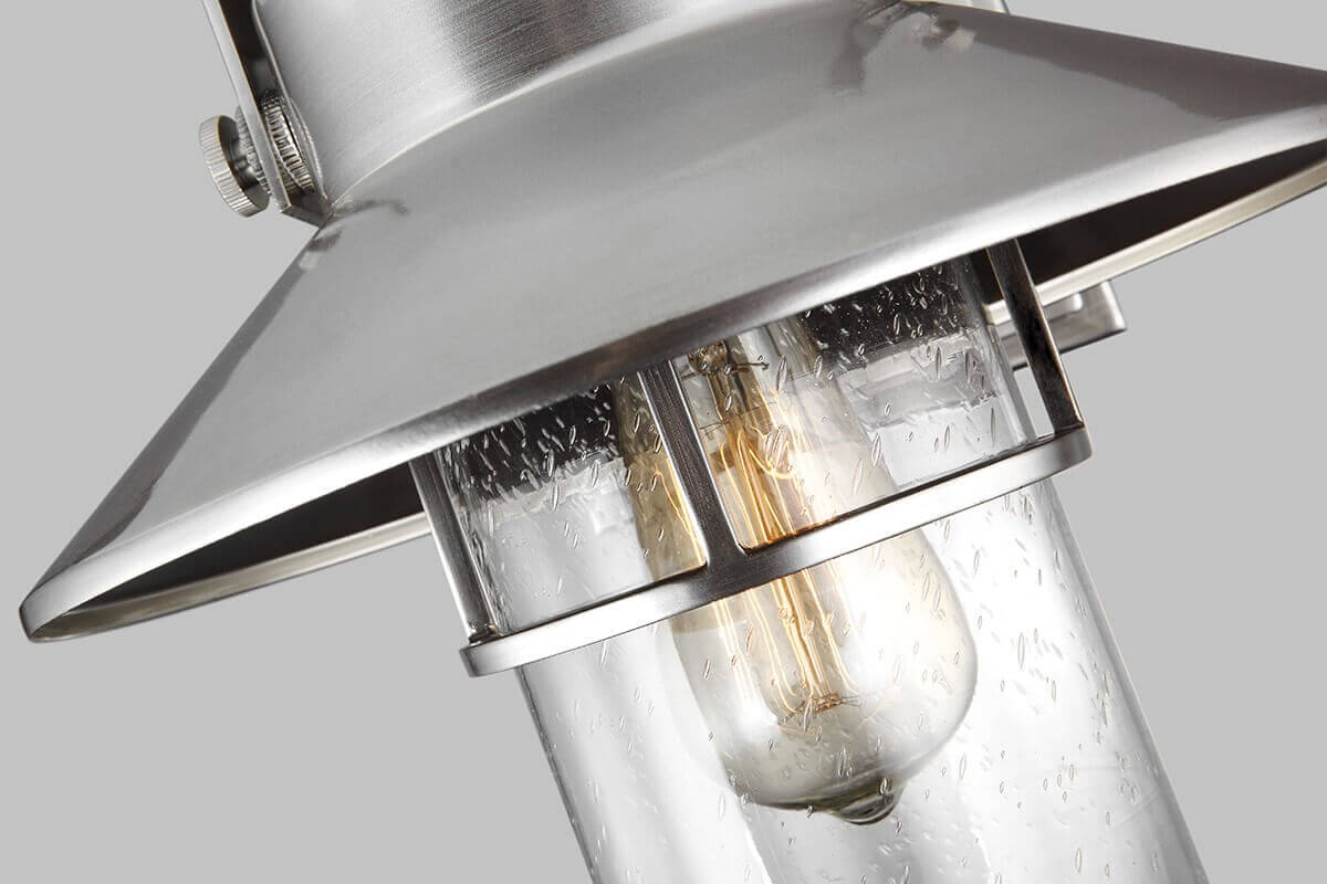 Gros plan sur le verre moucheté et l'ampoule à filament sous l'abat-jour conique.