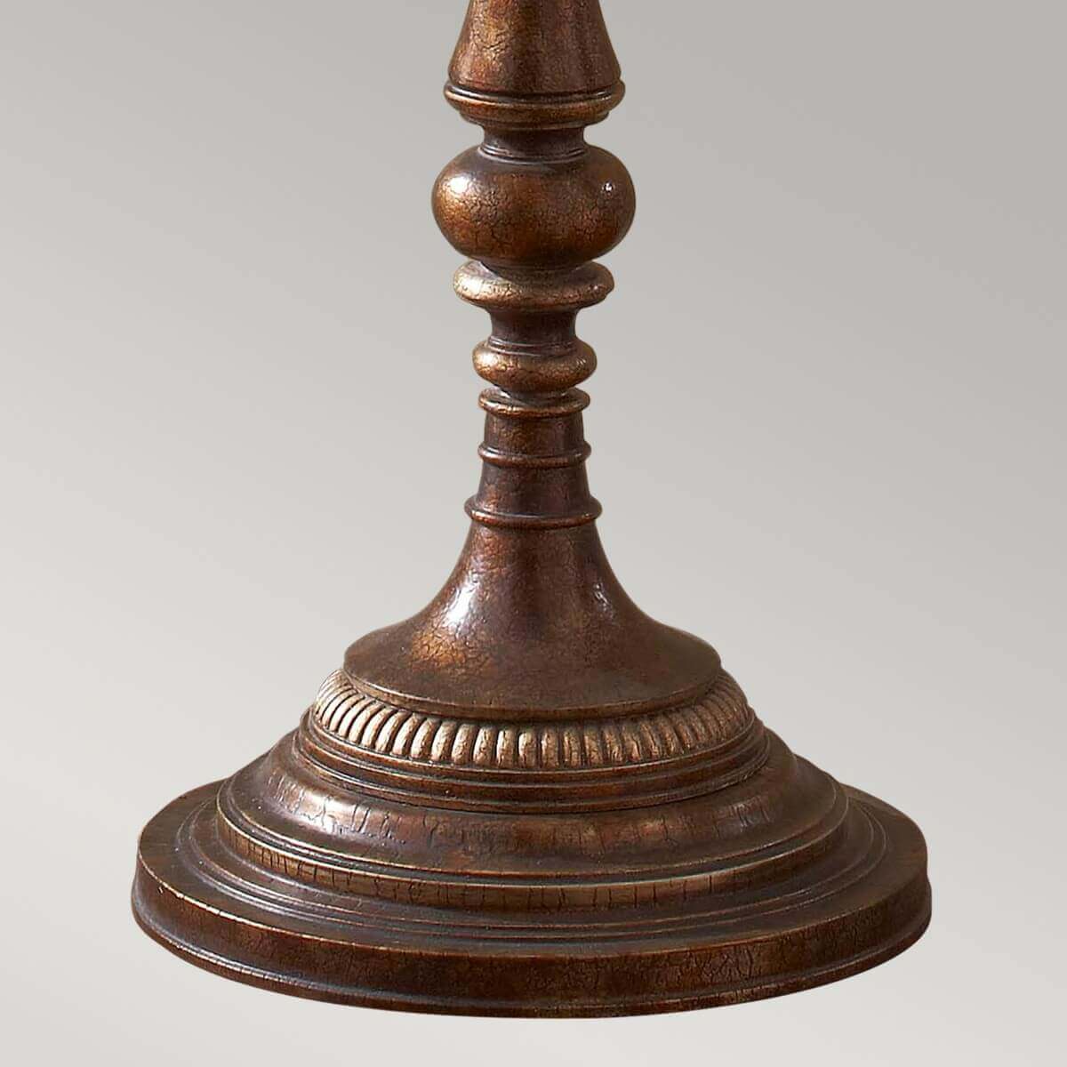 Détail de la base ronde moulurée et cannelée au bronze vieilli à patine décorée
