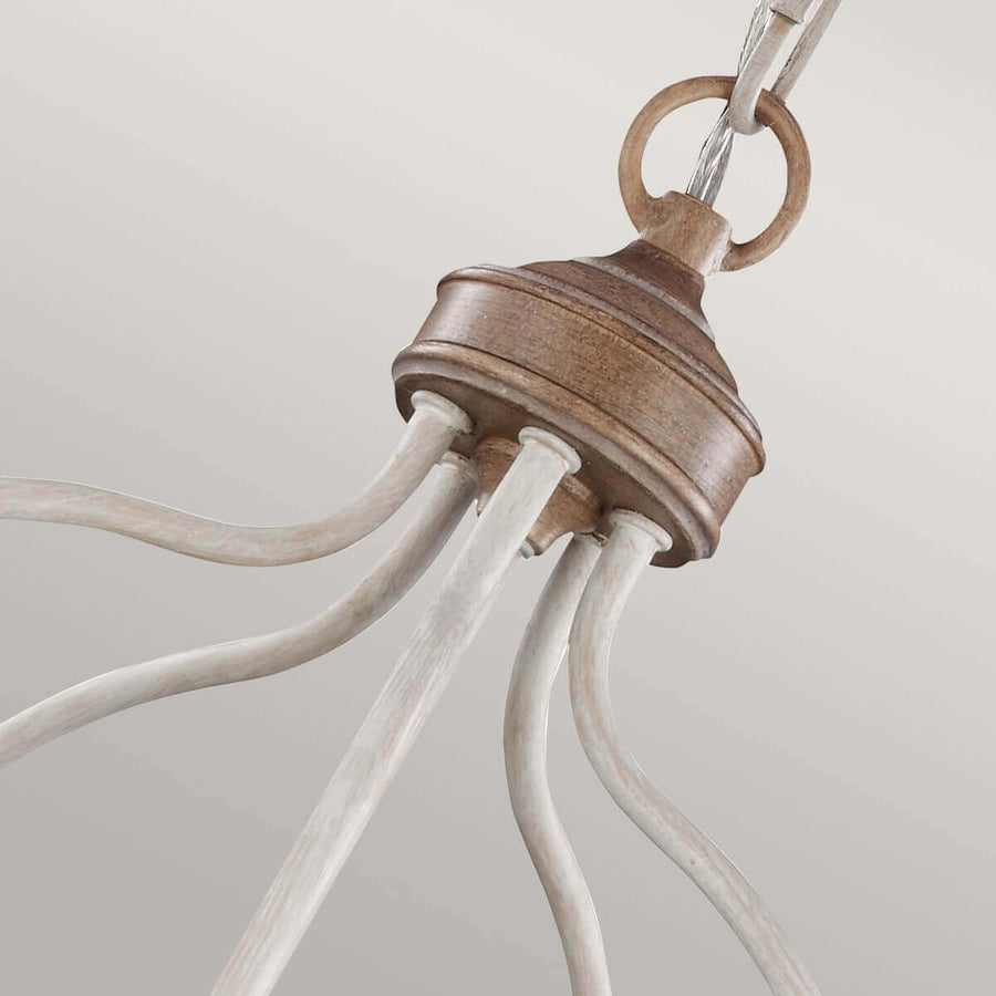 Gros plan sur le raccord supérieur en bois et les bras courbes blancs du luminaire.