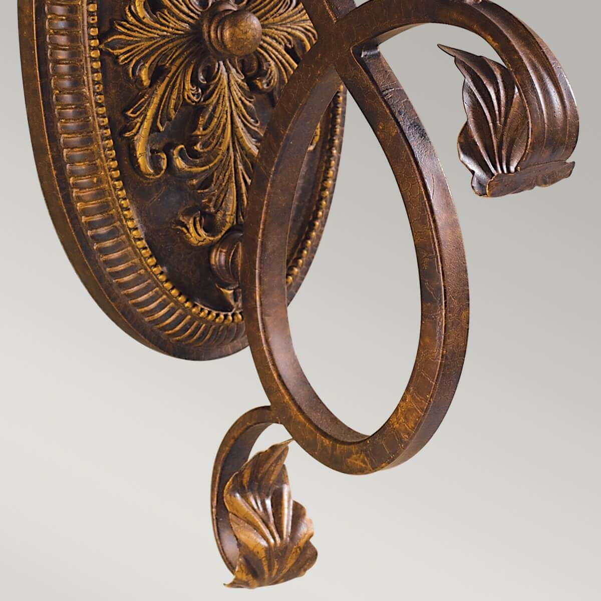 Détail du bras métallique recourbé en boucle et de la feuille sculptée