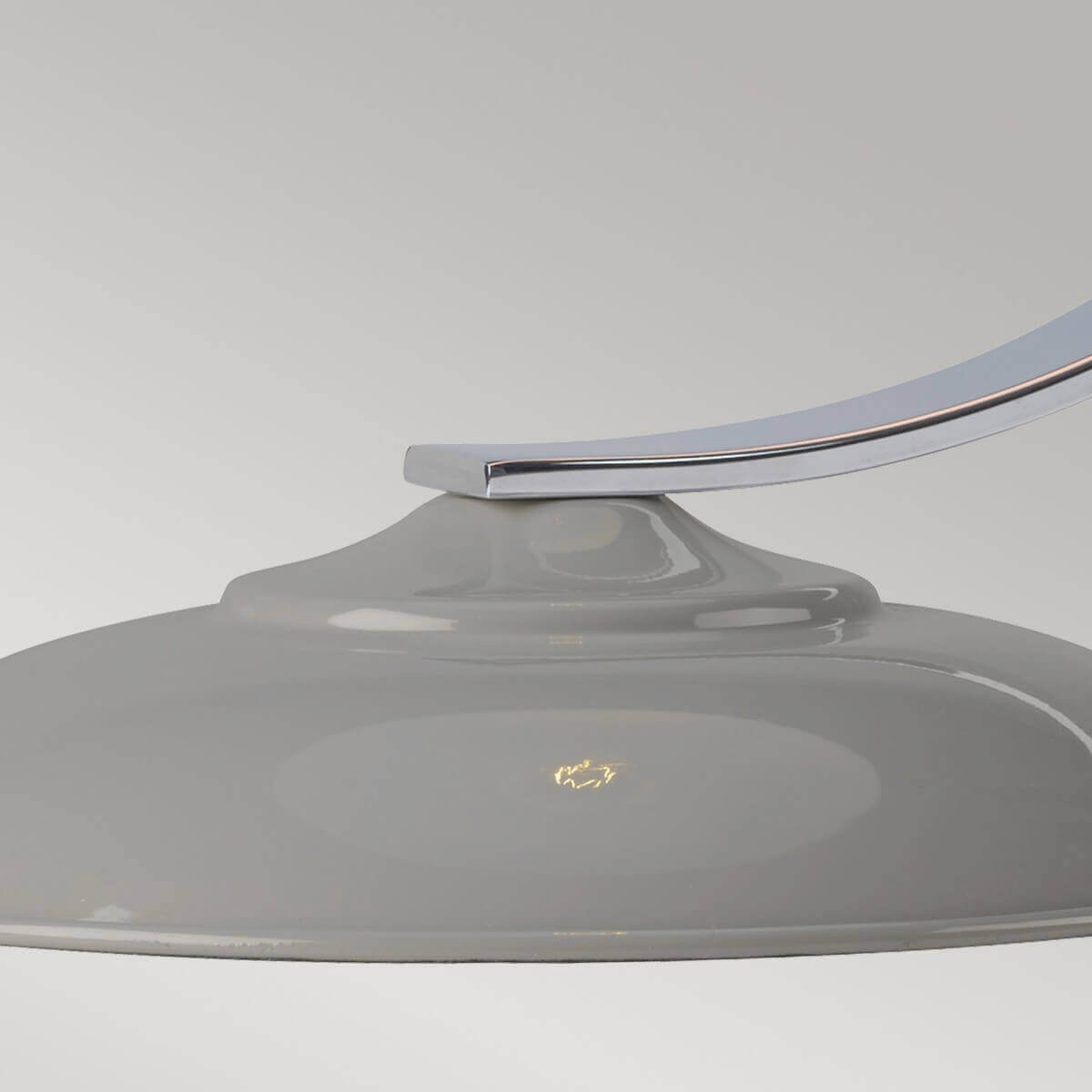 Détail de la base ronde grise brillante et de l'attache chromée