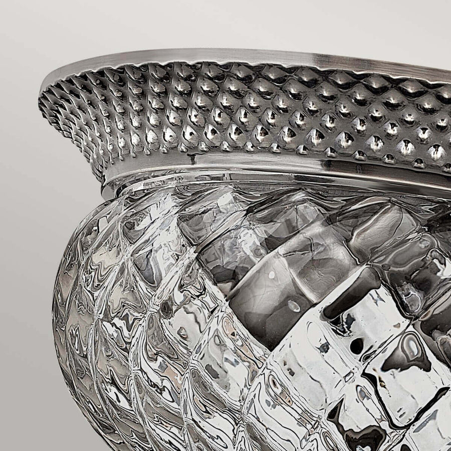 Détail de la couronne métallique perforée en nickel bordant le verre moulé