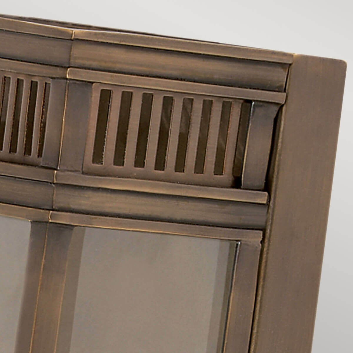 Détail du haut de l'applique montrant la grille ajourée en bronze brossé