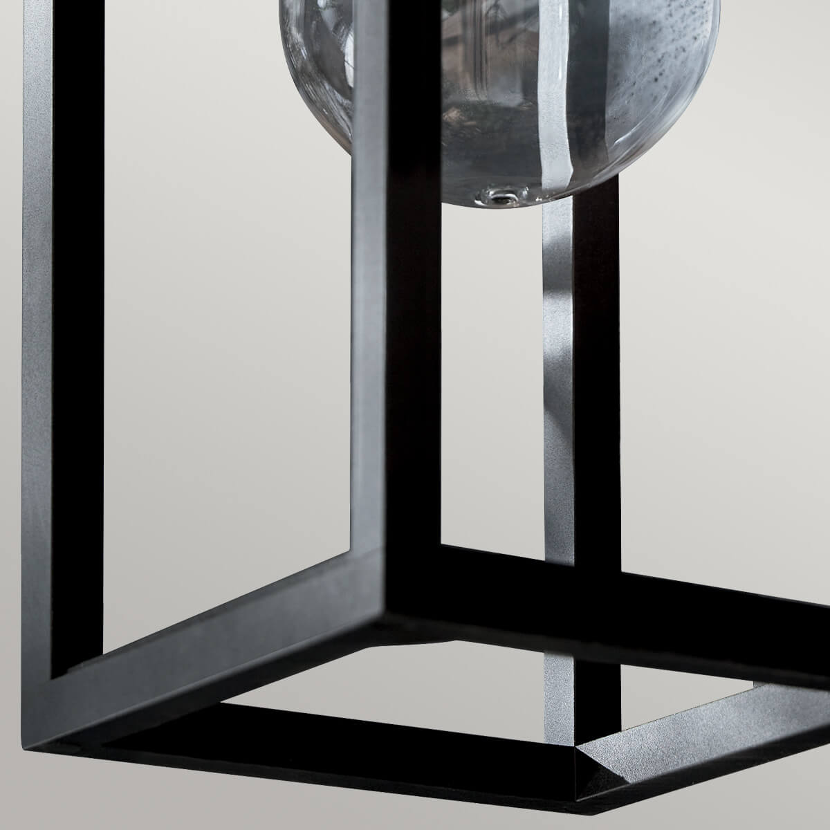Vue rapprochée du bas du cadre carré noir et du verre arrondi