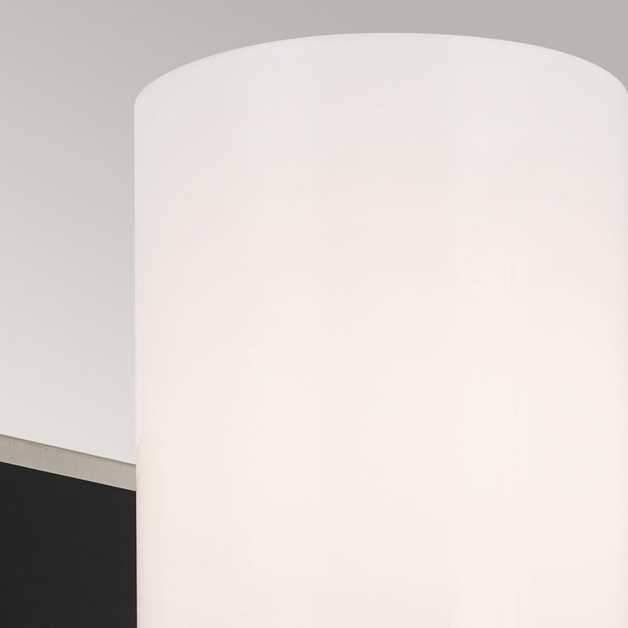 Détail du diffuseur cylindrique en verre blanc opalin, lumière douce.