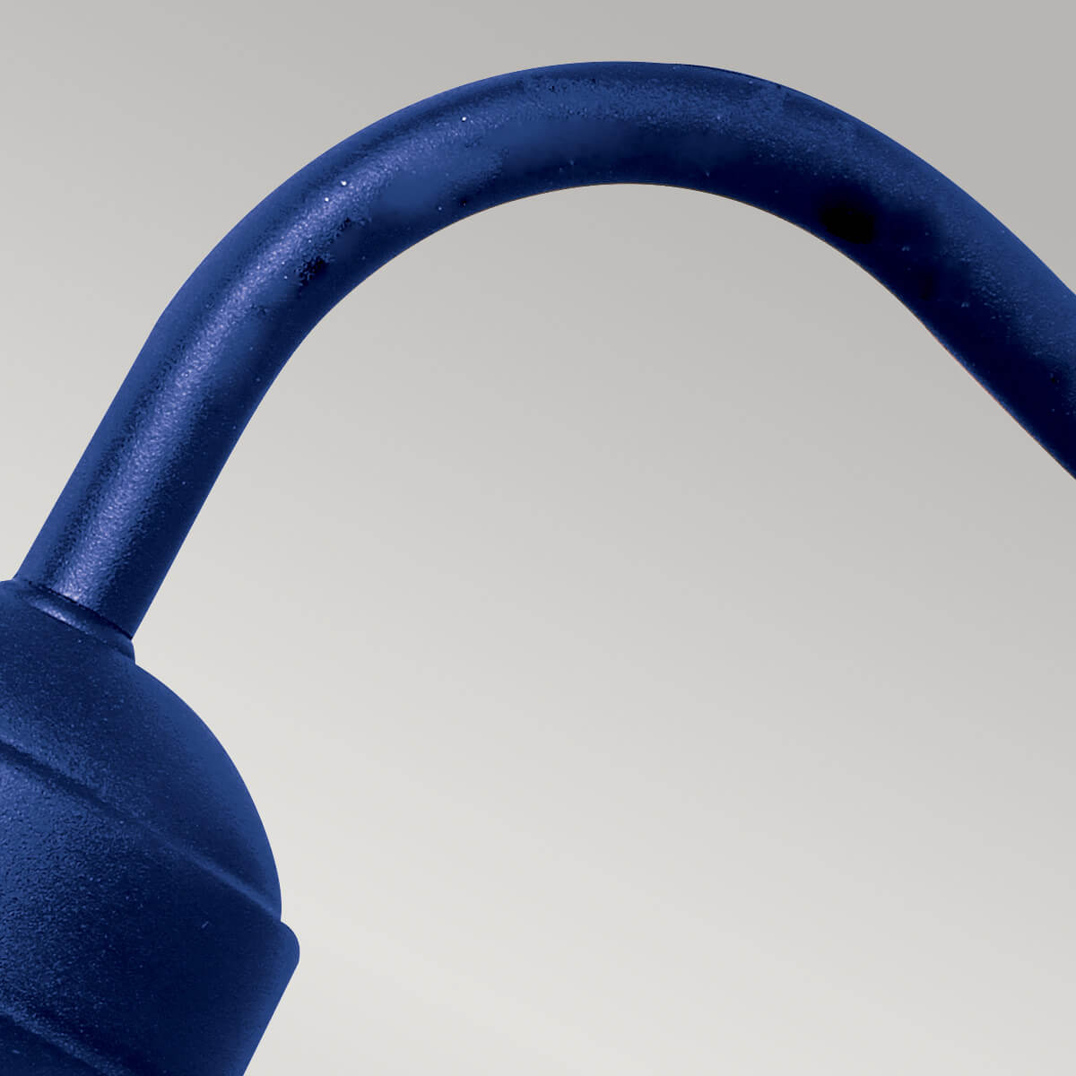Détail rapproché de la courbure du bras en métal bleu texturé