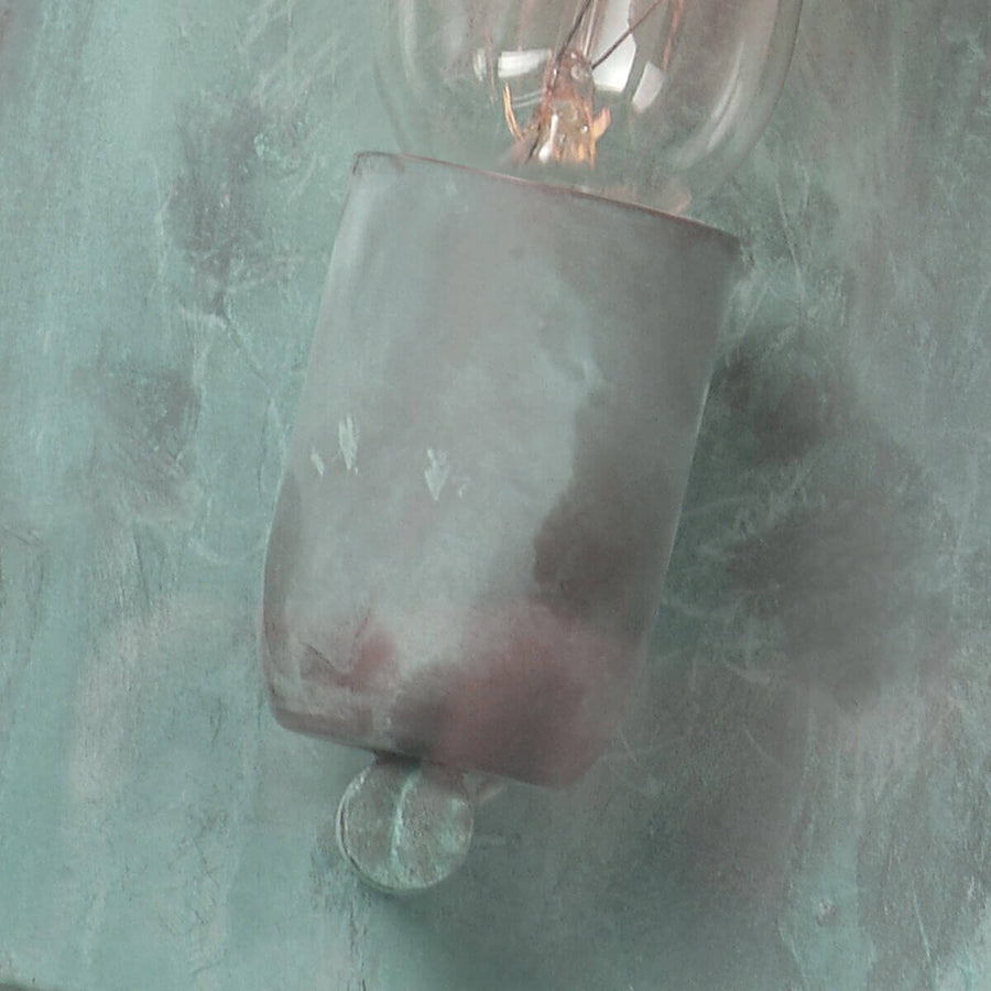 Détail de la douille et de l'ampoule sur fond de tôle verdie