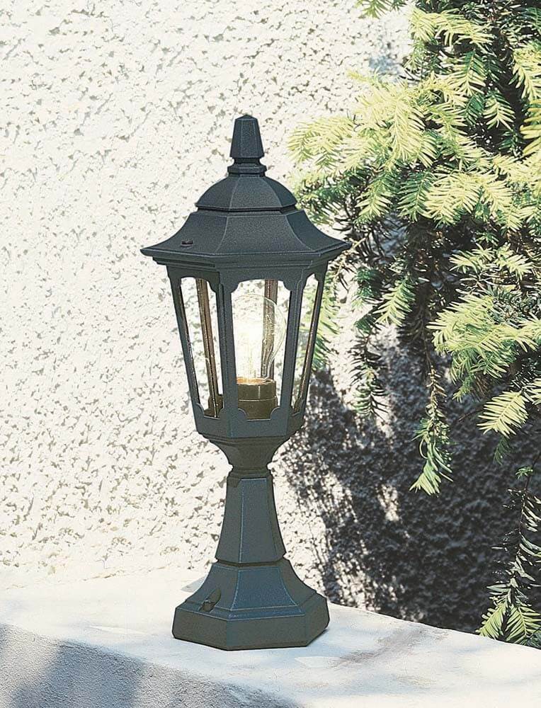 Mise en ambiance du lampadaire posé sur un muret, mur crépi et feuillage