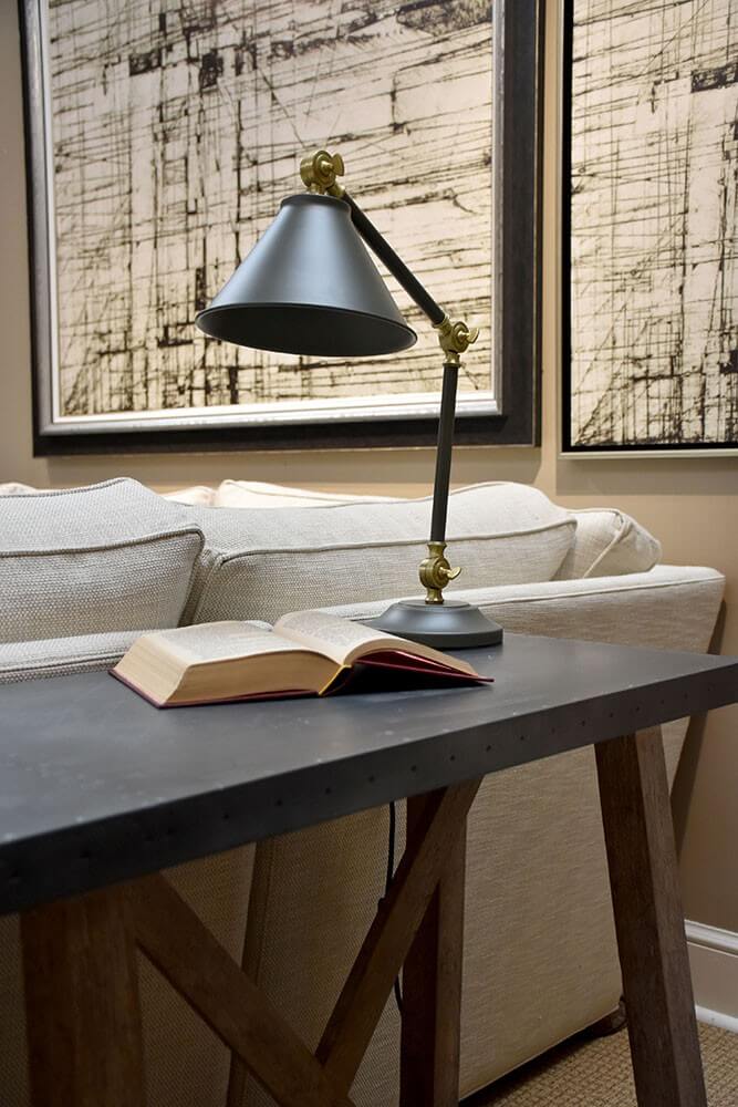 Gros plan de la lampe sur table, abat-jour gris et rotules en laiton