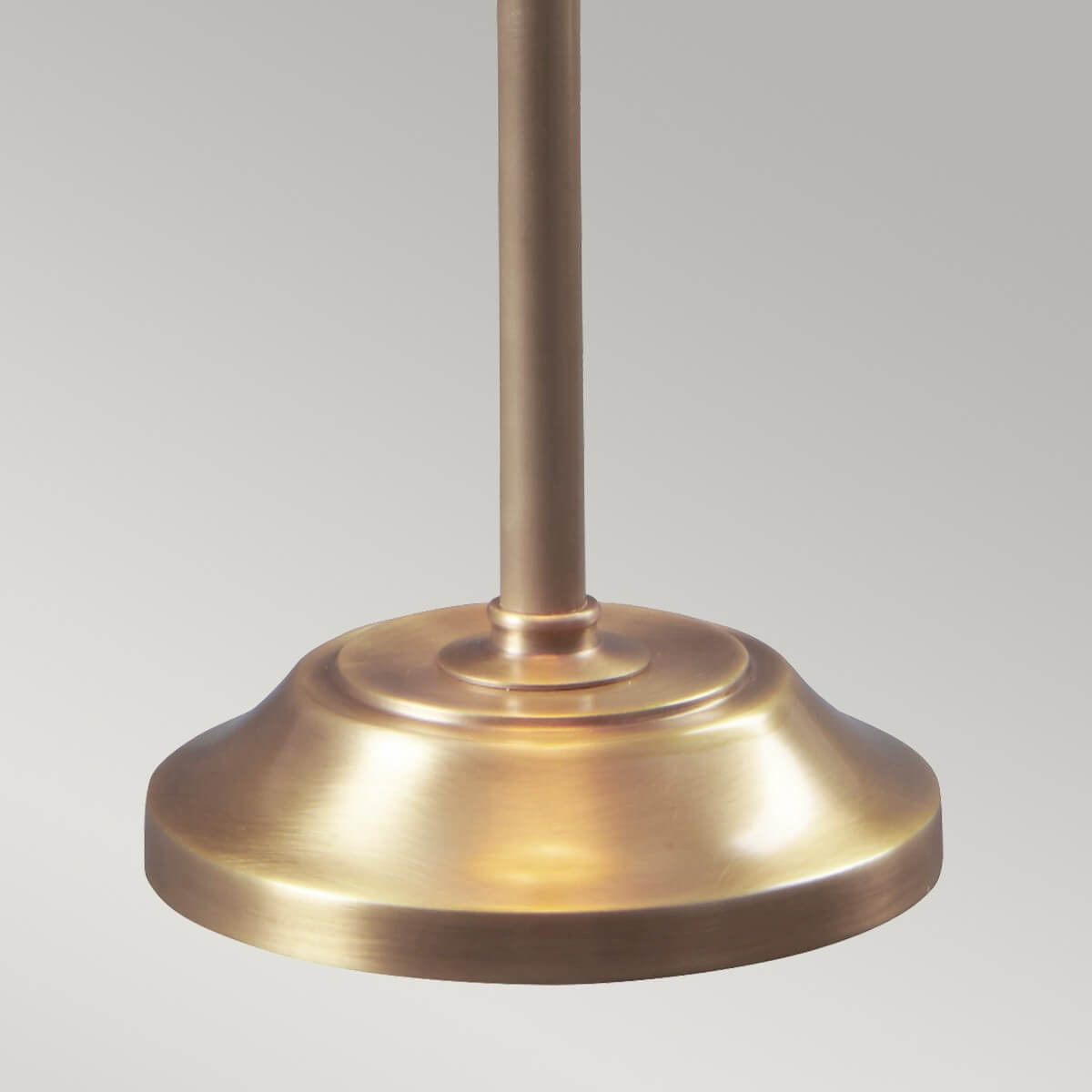 Détail de la base ronde et plate en laiton brossé aux reflets dorés