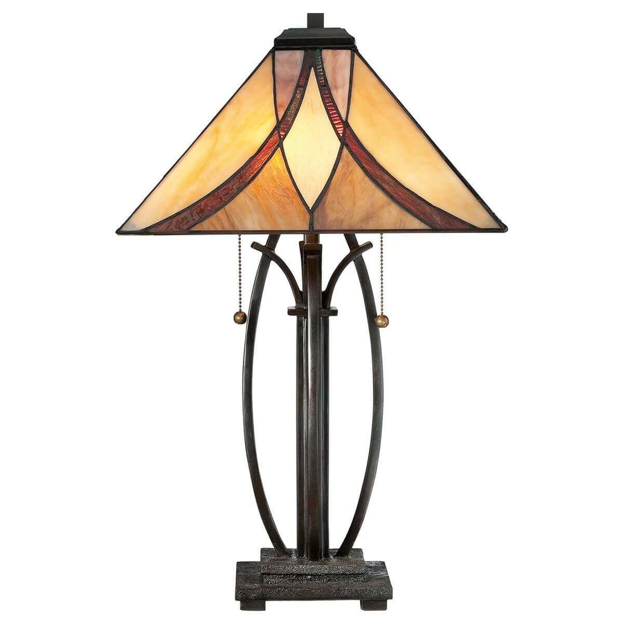 Lampe complète de face sur fond blanc, abat-jour en verre coloré et base métallique ouvragée.