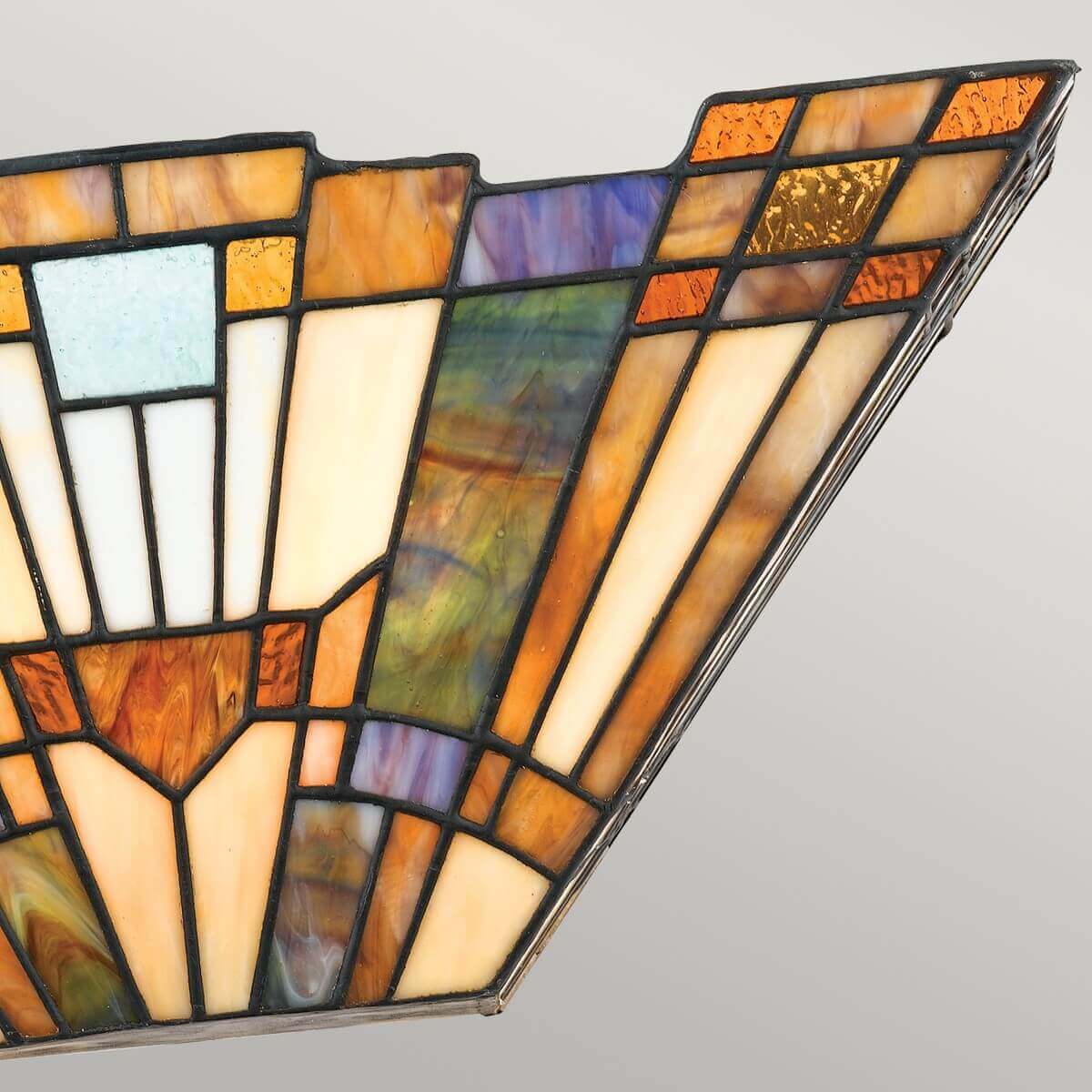 Vue rapprochée de l'angle supérieur droit, avec bordure métallique et cabochons de verre.