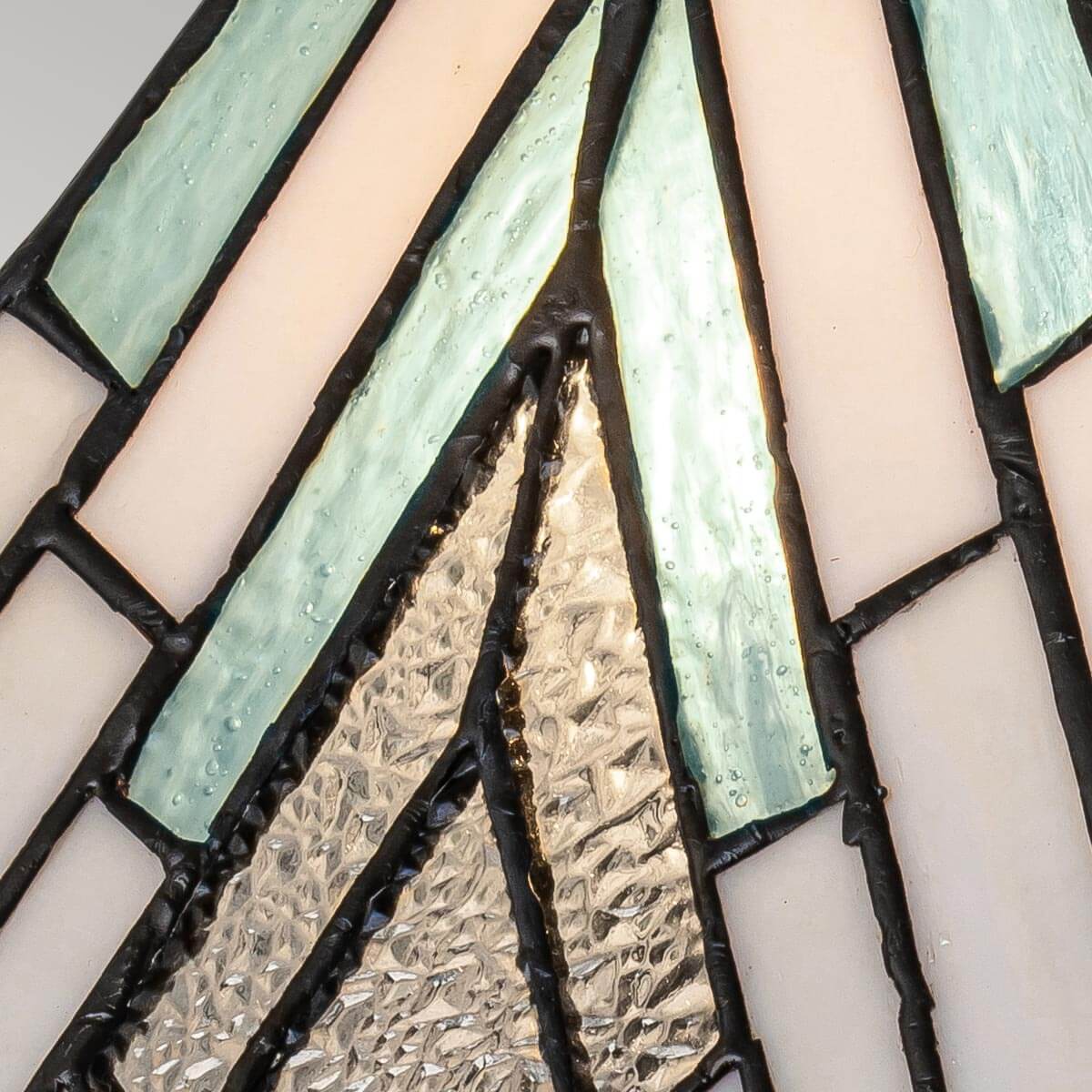Gros plan sur les verres vert, blanc et martelé du motif serti