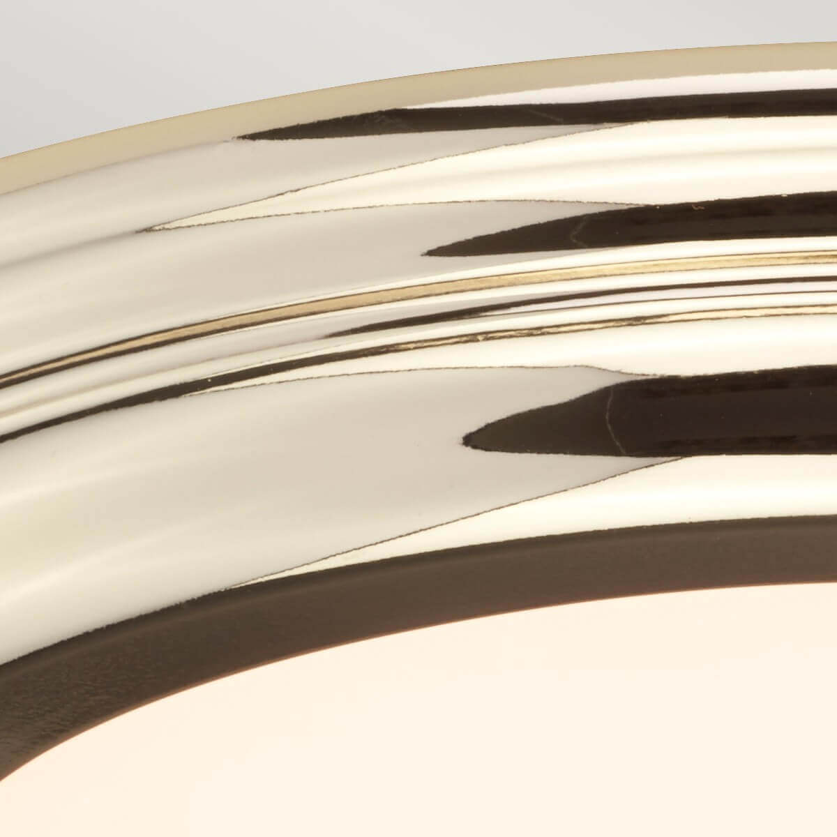 Détail du reflet miroir sur la bague en métal poli et bord du verre.