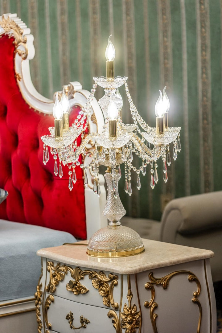 Lampe allumée sur une table de chevet en marbre, décor de chambre baroque
