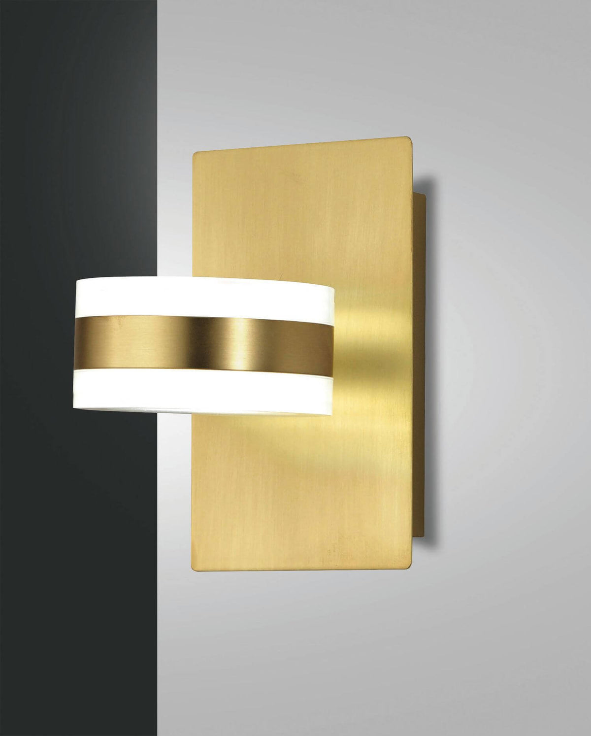 Applique murale en laiton brossé avec diffuseur cylindrique blanc et bandeau central doré.