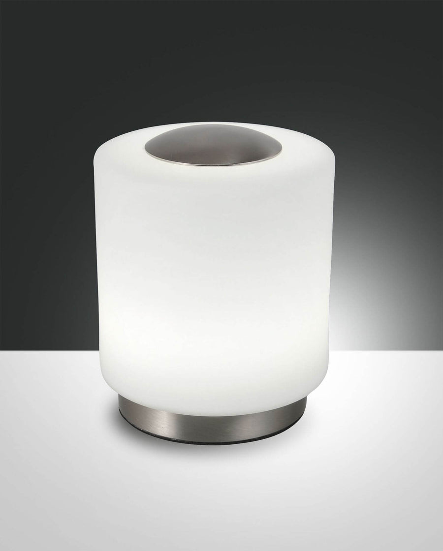 Lampe à poser cylindrique blanche, collet chromé, vue de face sur fond gris