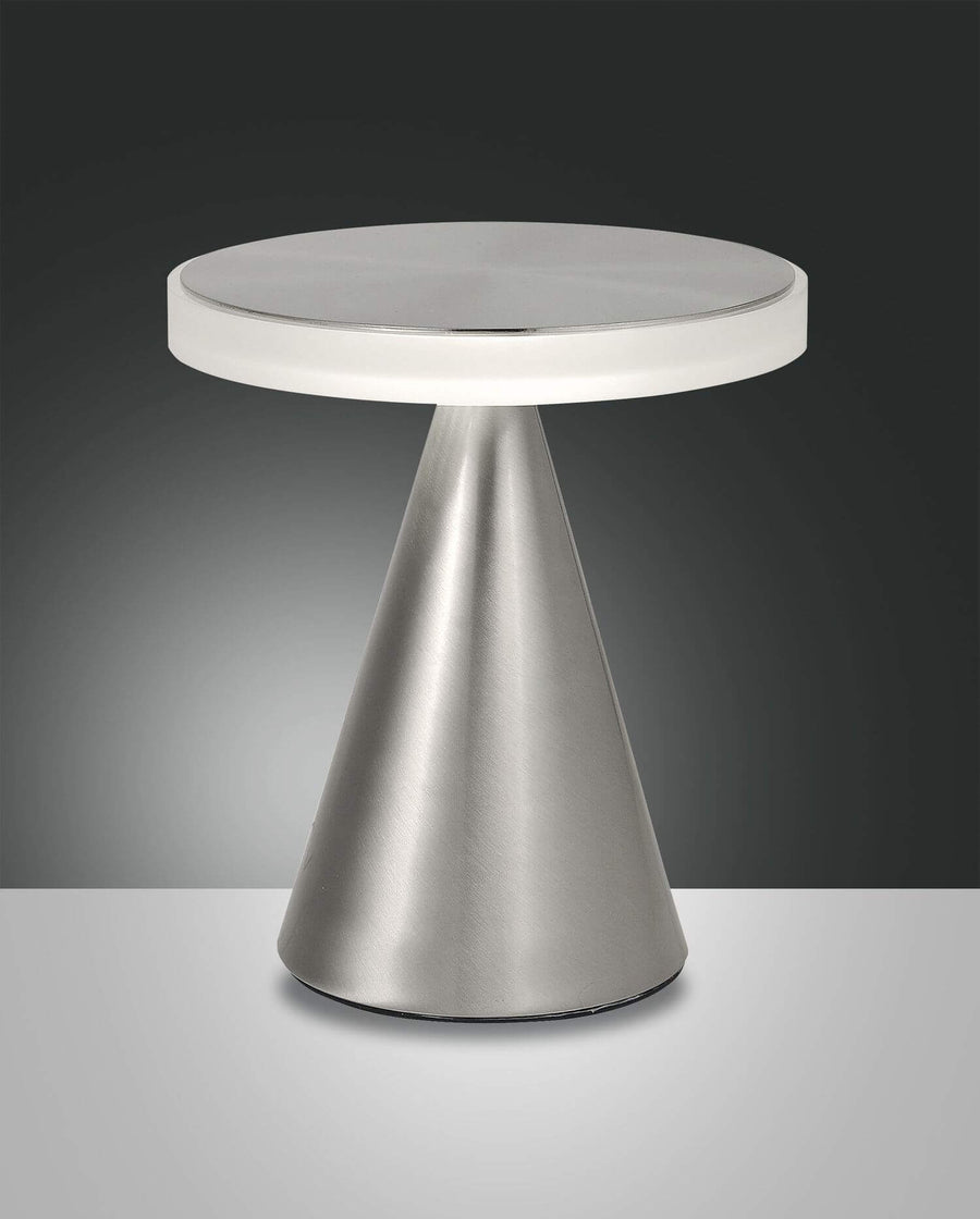 Lampe de face sur fond sombre, base conique chromée et diffuseur circulaire blanc allumé