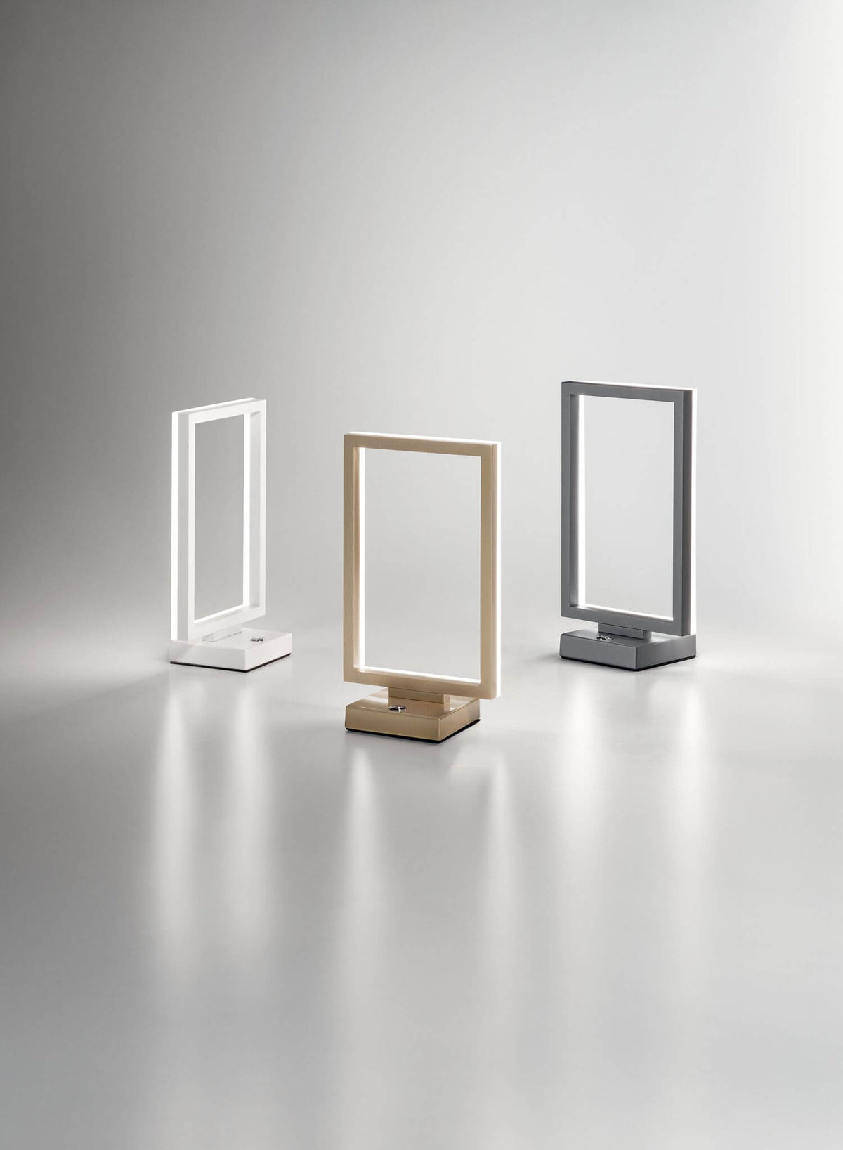 Trois lampes cadre rectangulaire alignées : finitions blanche, dorée et grise anthracite
