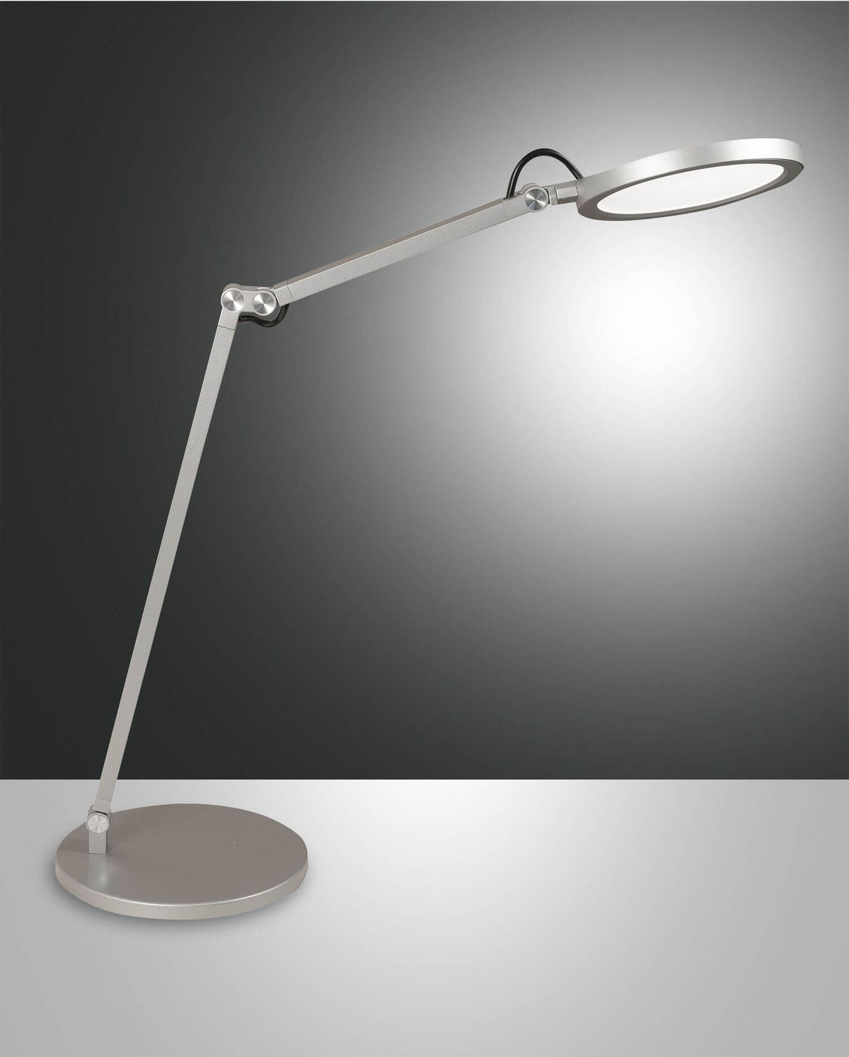 Lampe de bureau articulée en aluminium, tête ronde orientable, vue de trois quarts sur fond gris