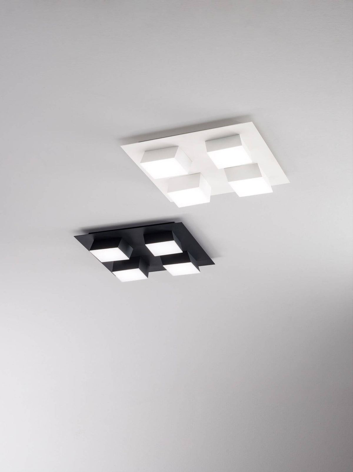 Deux versions du luminaire, noire et blanche, fixées au plafond