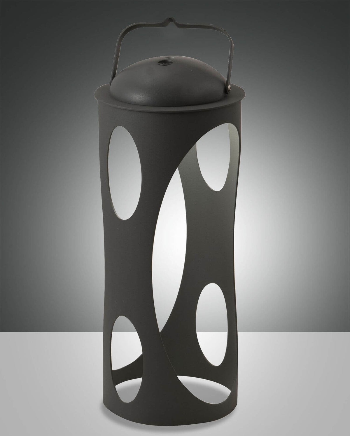 Lanterne cylindrique noire à découpes ovales posée, éclairée de l'intérieur