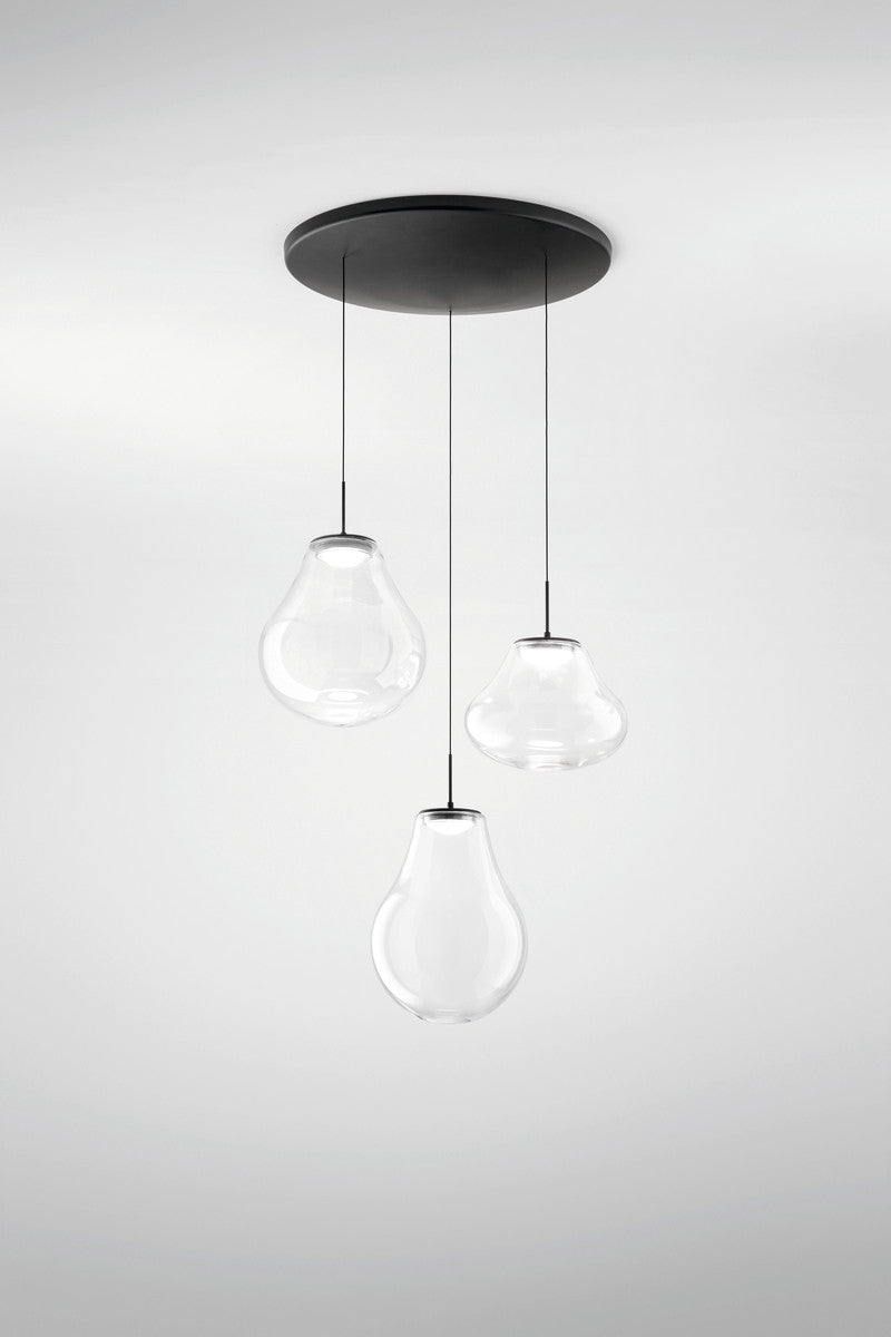 Vue rapprochée des trois globes en verre clair suspendus par de fins câbles