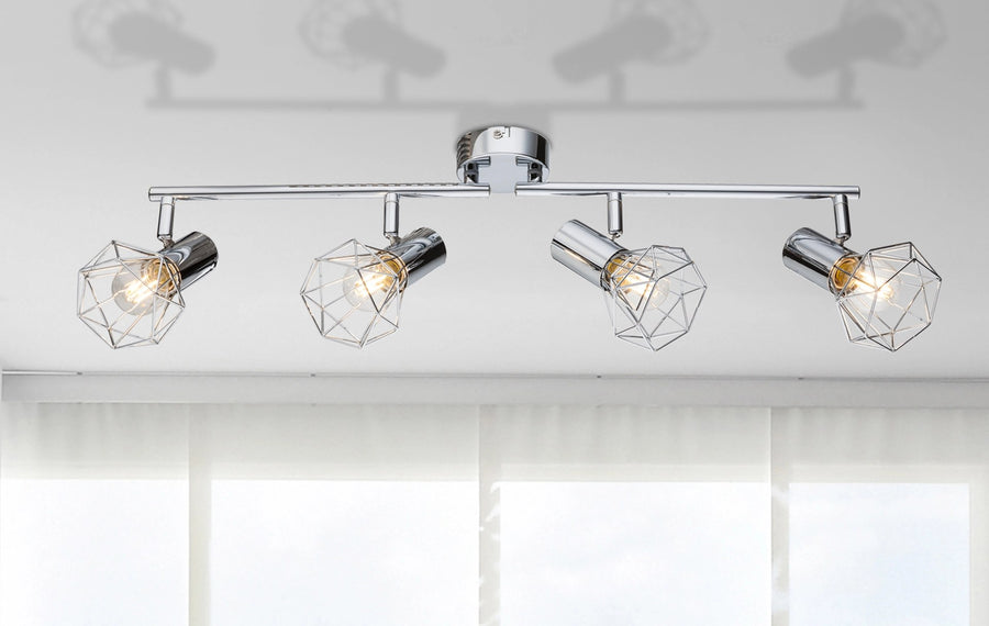 Spot chromé installé au plafond, quatre lumières allumées avec ombres portées au plafond.