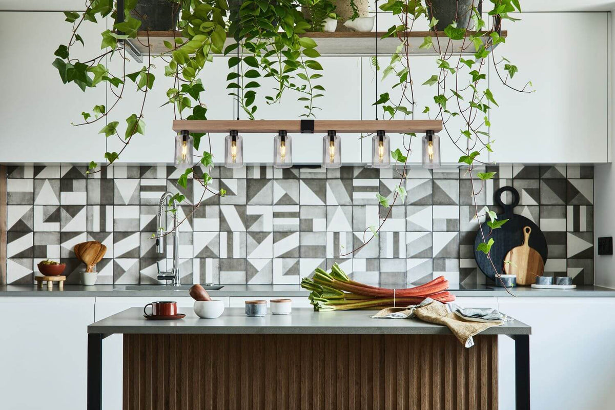 Mise en ambiance au-dessus d'un îlot de cuisine, suspension allumée parmi les plantes
