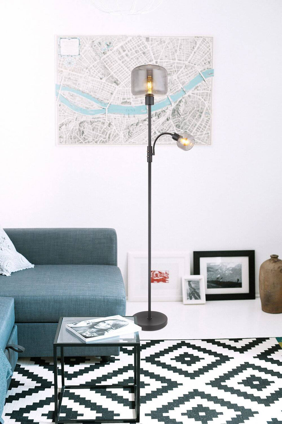 Lampadaire installé près d'un canapé bleu devant une carte encadrée