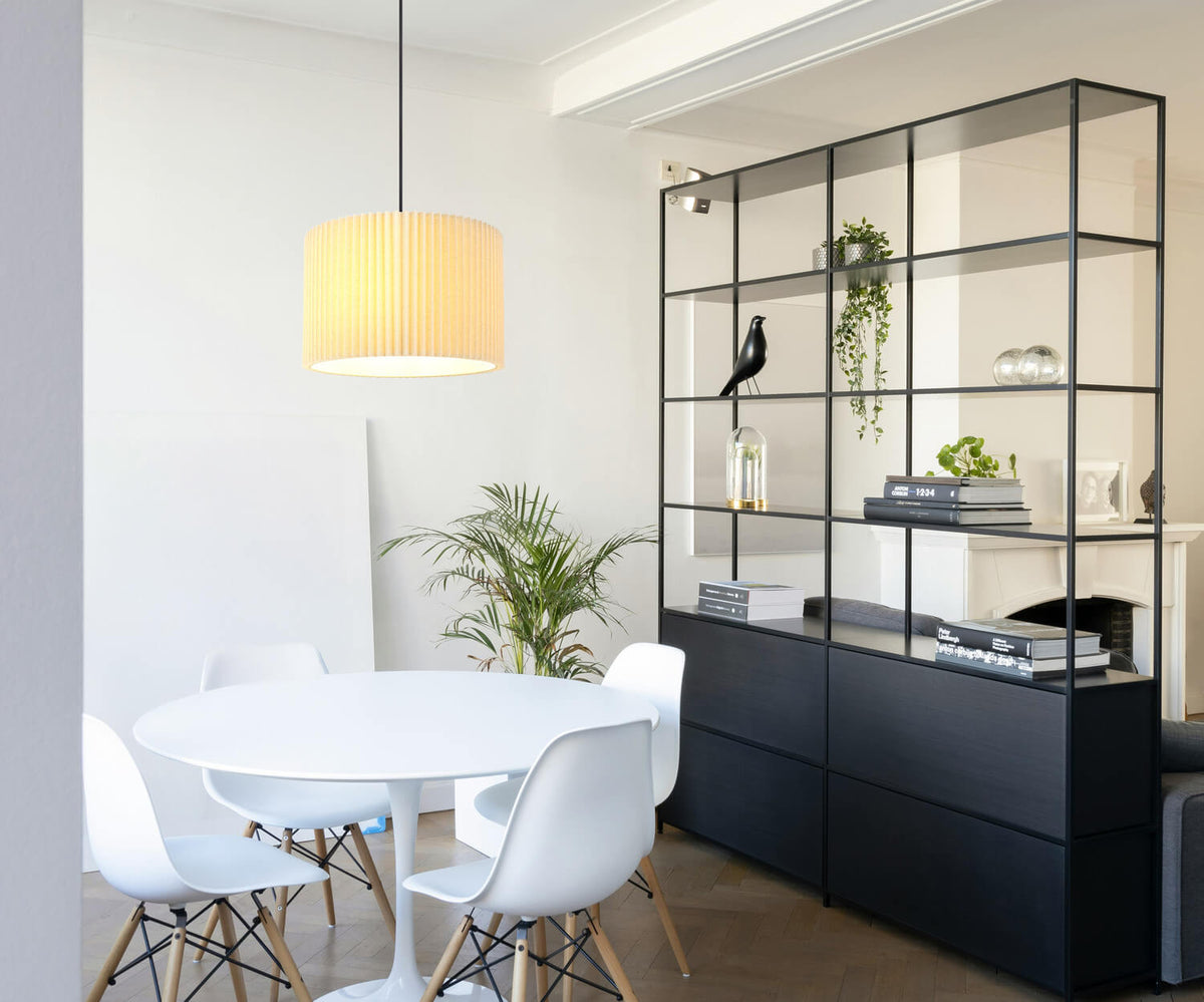 Mise en ambiance dans une salle à manger moderne, table blanche et étagère noire