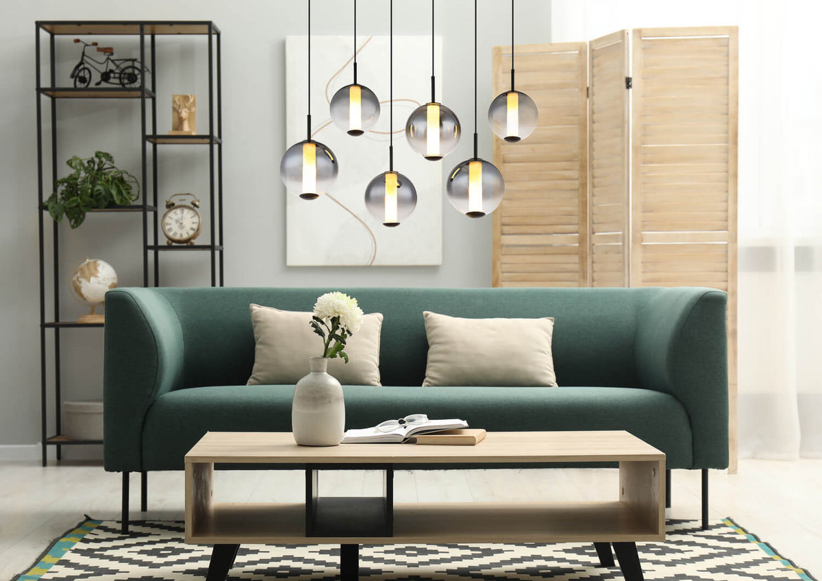 Mise en ambiance salon avec canapé vert et luminaire suspendu à globes