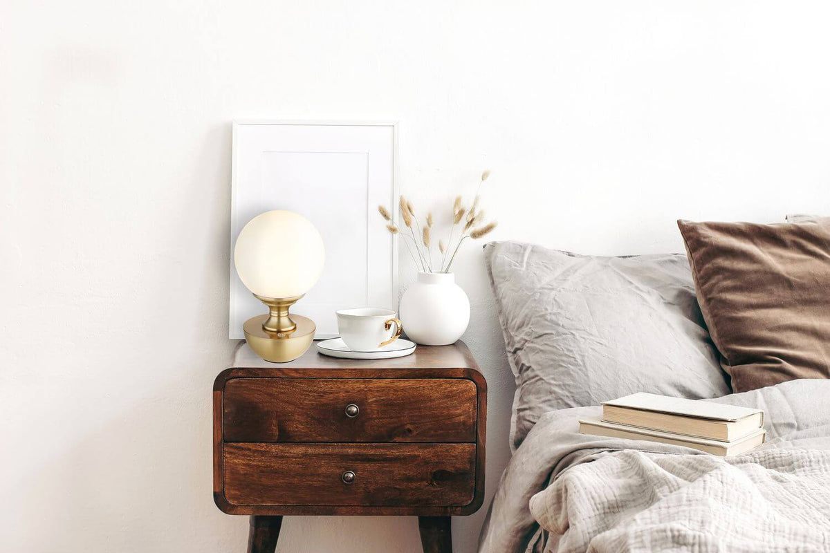 Mise en ambiance sur une table de nuit en bois près d'un lit
