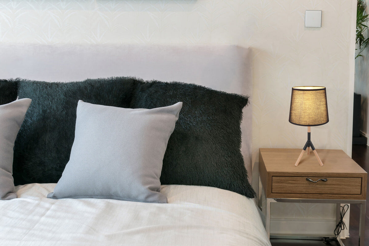 Mise en ambiance dans une chambre, lampe posée sur une table de chevet en bois