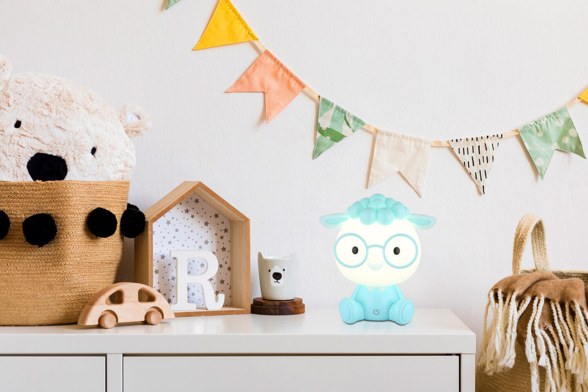 Mise en ambiance sur une commode de chambre d'enfant avec guirlande colorée